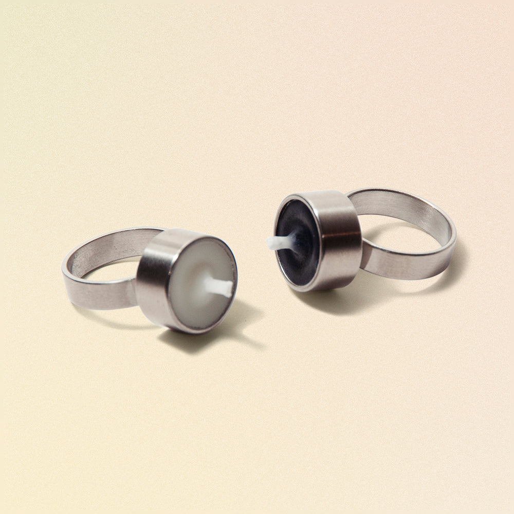 two rings with tiny candles on them that light up with wax and wicks